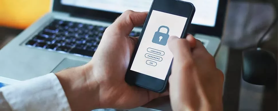 Person uses smartphone for secure login with a lock icon on the screen.