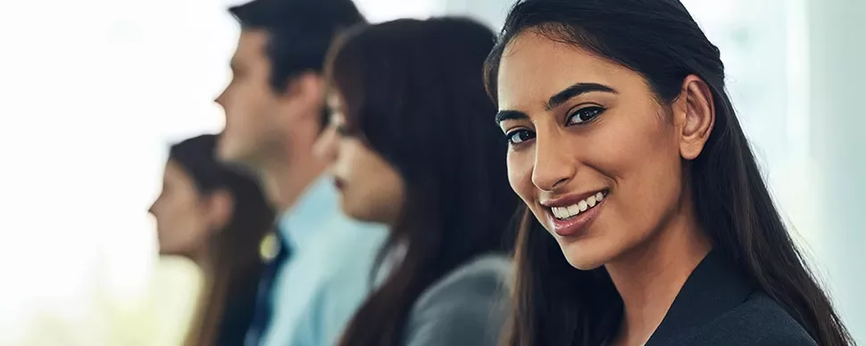Woman smiling with confidence in a professional setting.