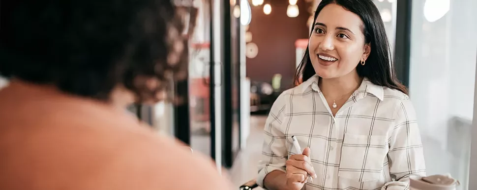 Two people having a friendly conversation in a cozy cafe.