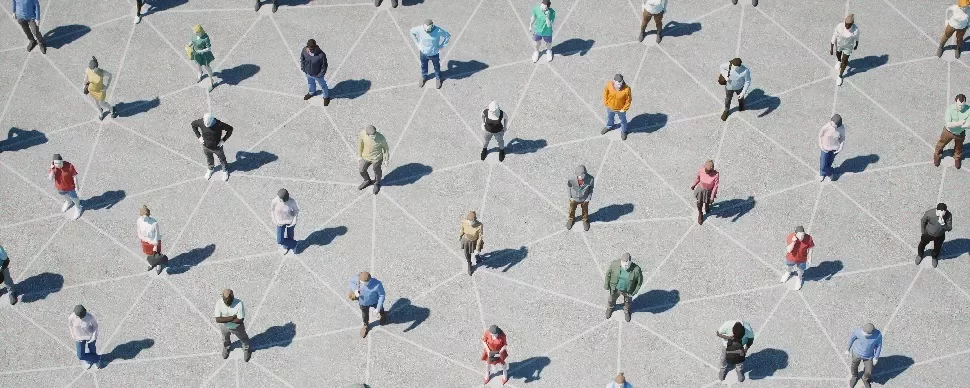 Aerial view of people standing on a geometric pattern on concrete, each casting a shadow.