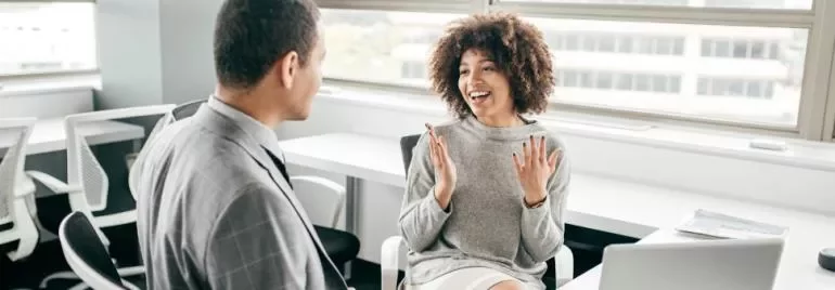 Two colleagues having a cheerful discussion in a modern office.