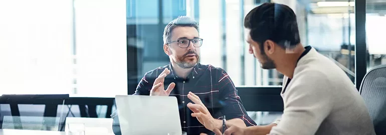 Two men discussing ideas in an office meeting.