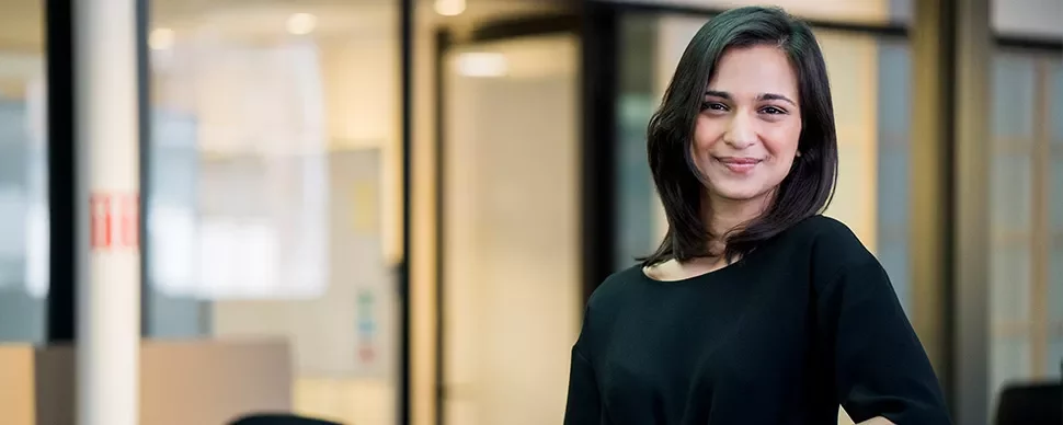 Person smiling in a modern office setting.