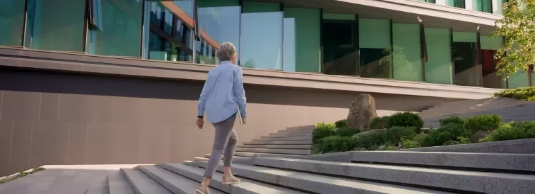 A senior female professional walking up the stairs