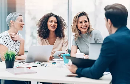 Diverse group having a meeting with laptops and coffee.