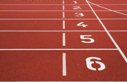 Red running track with white numbered lanes 1 to 6
