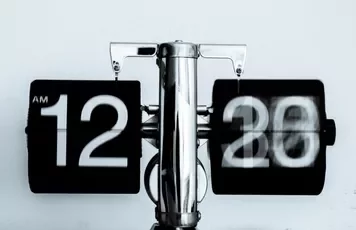 Retro flip clock showing 12:20 AM with a blurred motion effect.