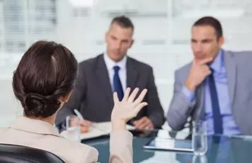 Woman in a business meeting with two men in suits.