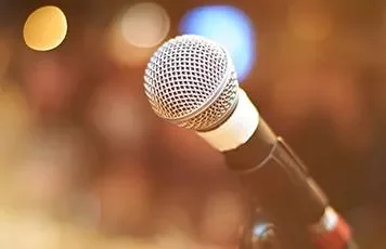 Close-up of a microphone on a stand with a blurred background.