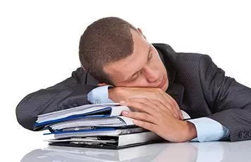 Man in suit sleeping on a pile of documents.