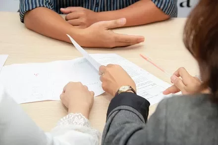 People reviewing documents at a desk.